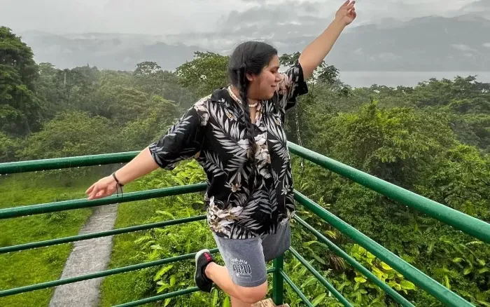 A female student making a pose on a balcony.